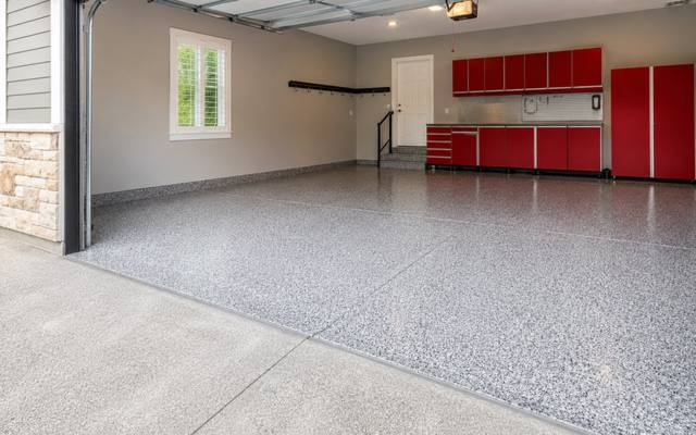 Light flake epoxy floor in a garage with red cabinets in Wellington County