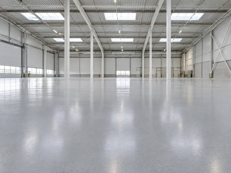 Open warehouse floor with a light grey epoxy coating in Wellington County